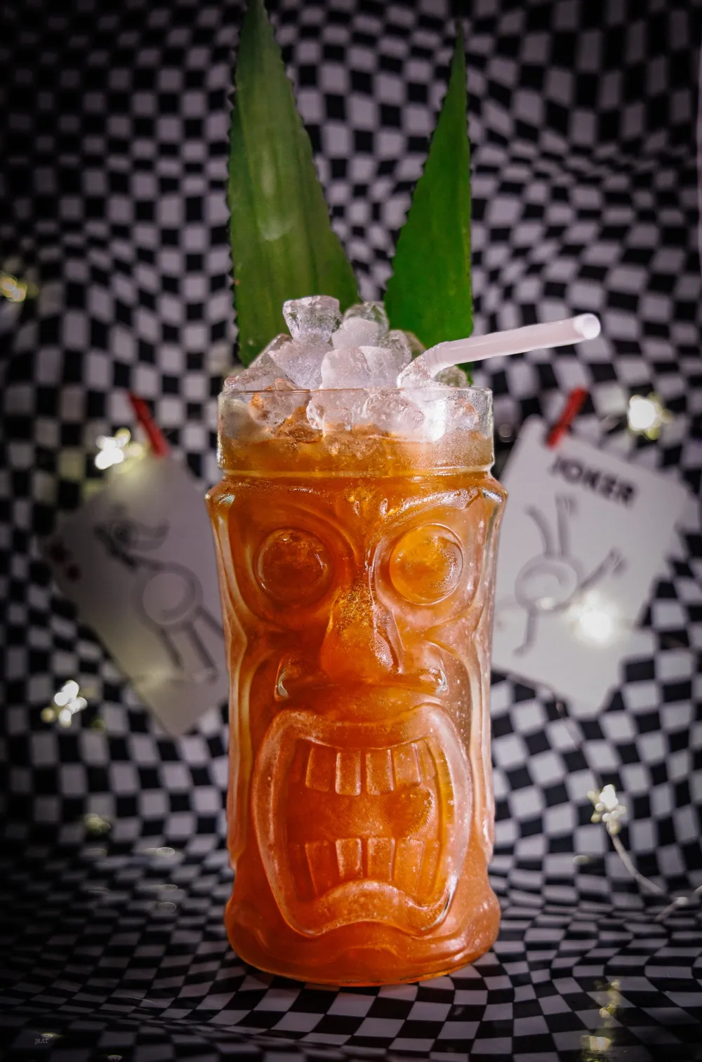 Passion Fruit Jungle Bird in a tiki glass with pineapple fronds