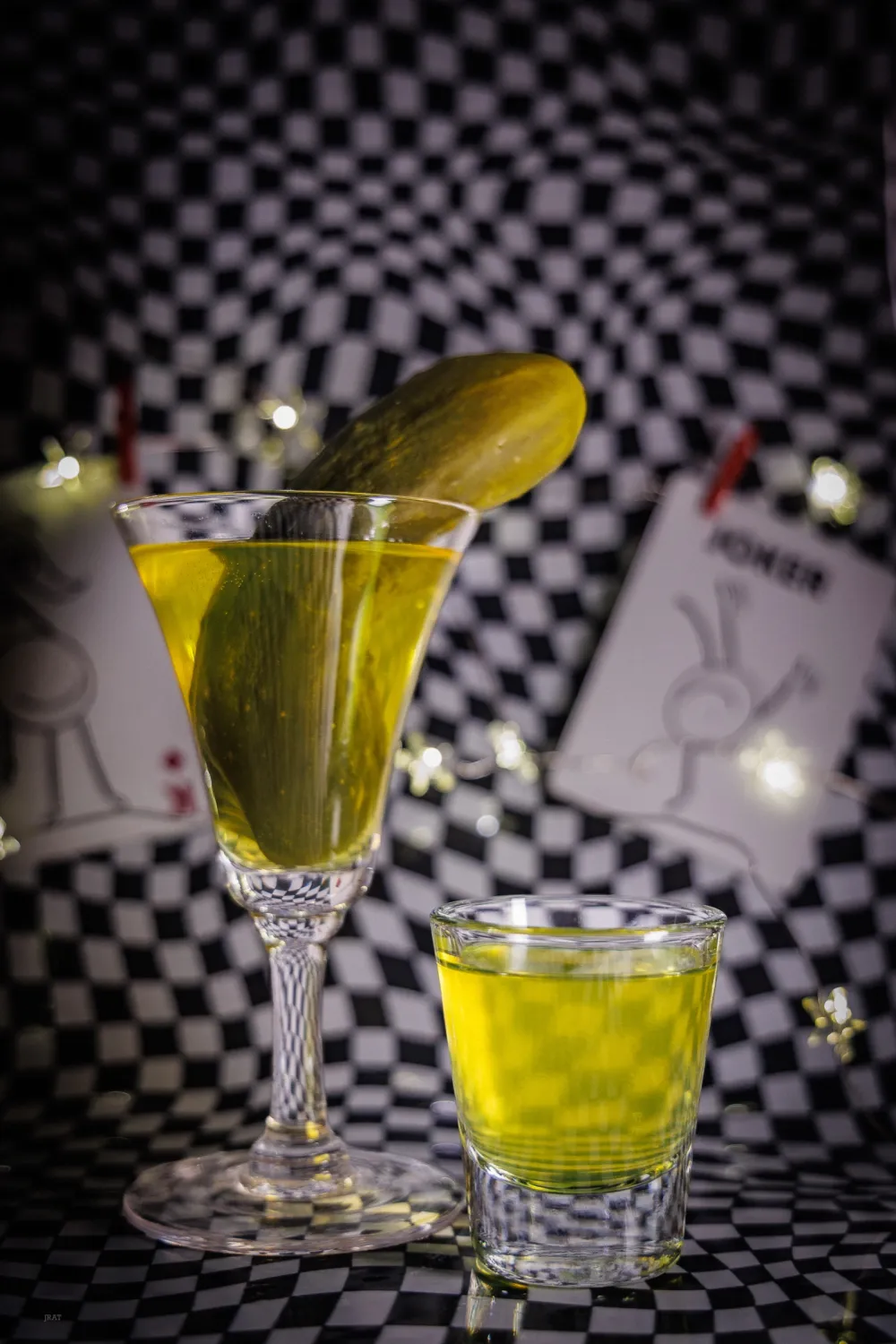Pickle shot with a whole pickle in a glass beside it