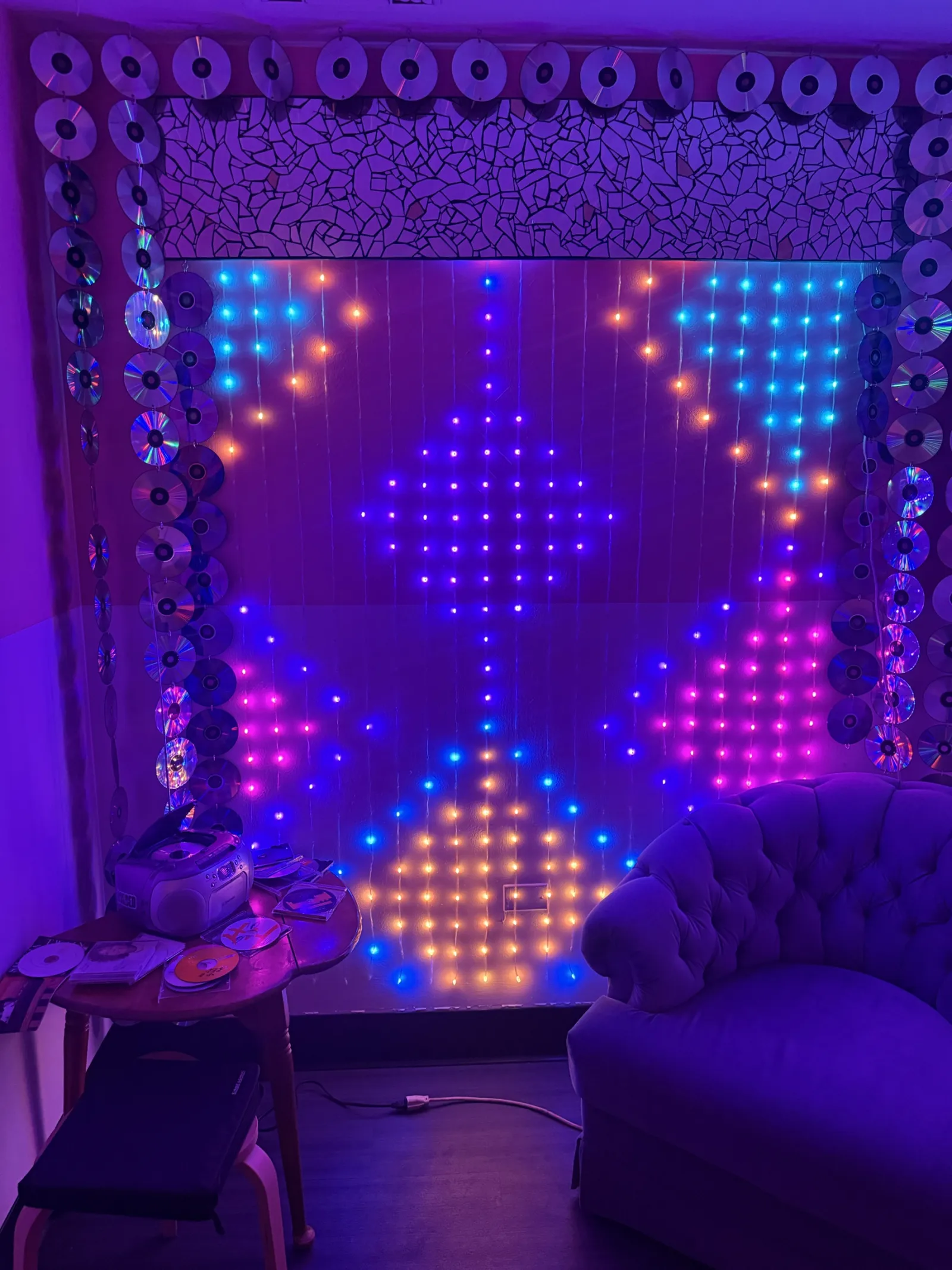 The lounge with a glowing LED diamond wall and a velvet chair