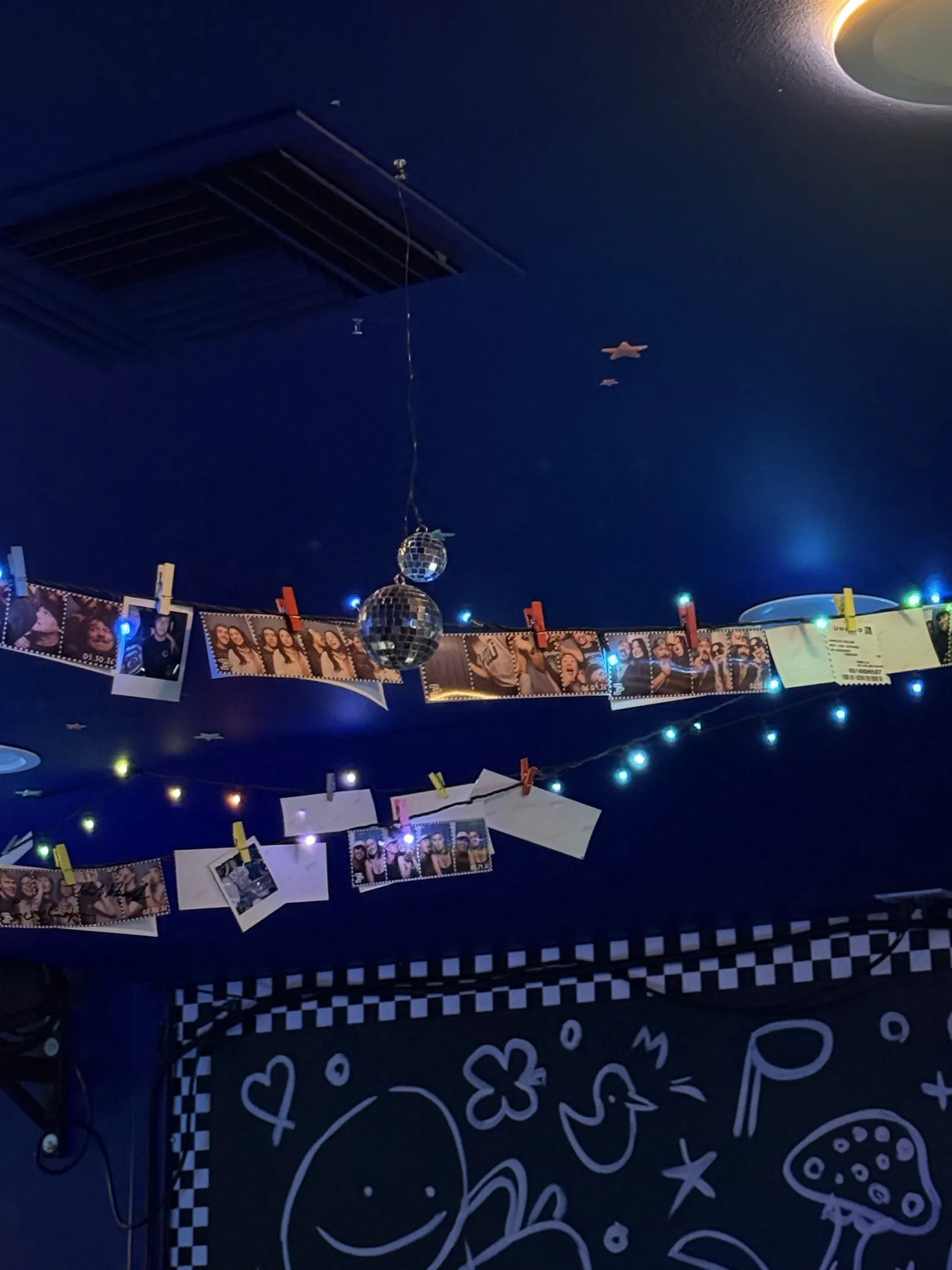 Polaroids clipped to a string of lights over the doodle wall art